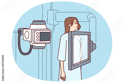 Woman suffering from cancer stands near x-ray machine making medical examination for diagnosing oncological disease. Girl during mammogram for early detection of breast cancer undergoes radiography