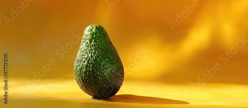 Close-up image of a spoiling avocado on a yellow backdrop, highlighting the concept of unhealthy overripe tropical fruits with room for additional content.