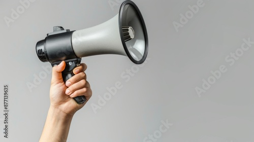 Hand holding a megaphone against a gray background