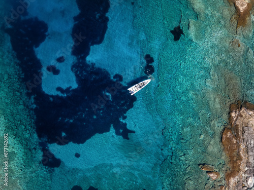 Fototapeta Naklejka Na Ścianę i Meble -  Aerial view of a rib boat moored at the beautiful shore of Kea - Tzia island in Greece during a hot summer day