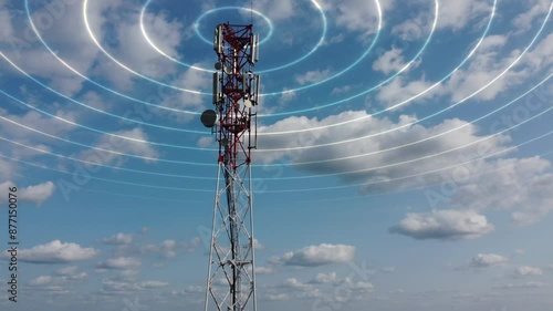 Mobile telecommunication cell tower with transmit telecommunication signal. 4G 5G mobile network. Telecommunication tower against a blue sky with clouds transmitting a luminous signal around it. 4k.