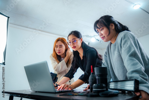 Female photographer meeting to select photos and check colors in studio