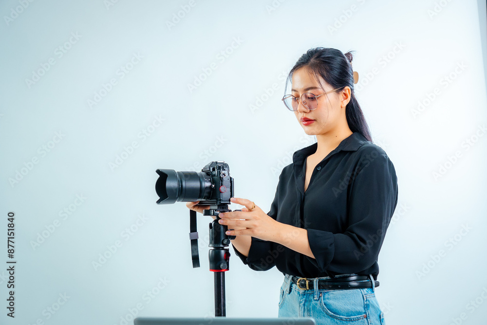 Obraz premium Female photographer holding a camera in the studio