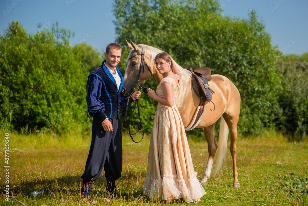A man and a young woman in 19th century clothing. A man leads a horse by the reins. Scene from the novel A man and a young woman in 19th century clothing. A man leads a horse by the reins. Scene from the novel