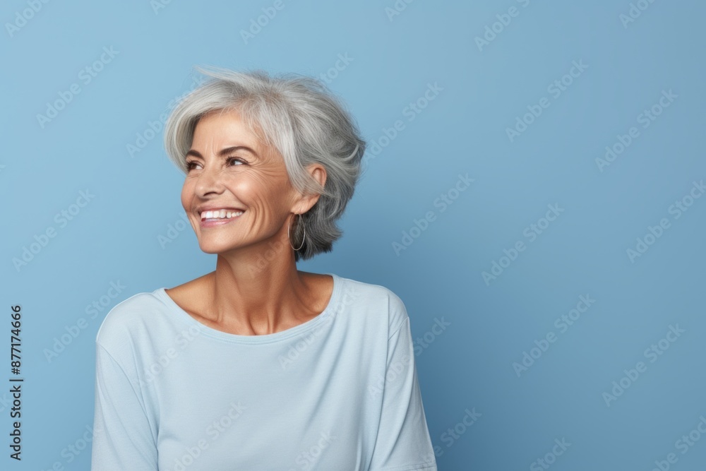 Portrait of happy senior woman looking at camera over blue background. Portrait of happy senior woman looking at camera over blue background.
