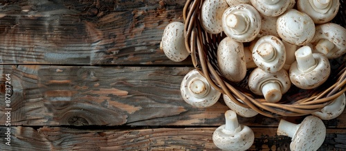 Freshly cut white mushrooms ideal for various dishes are displayed on a wooden background in a brown basket Top view with copy space image available