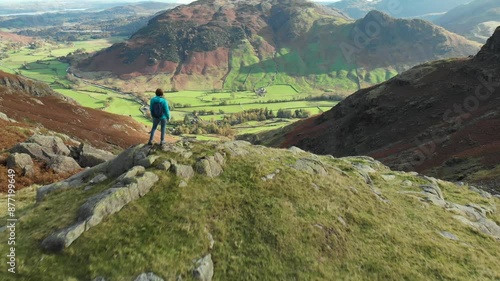 Aerial footage of female tourist enjoying view of Great Langdale valley in the Lake District, famous for its glacial ribbon lakes and rugged mountains, Cumbria, North West England.