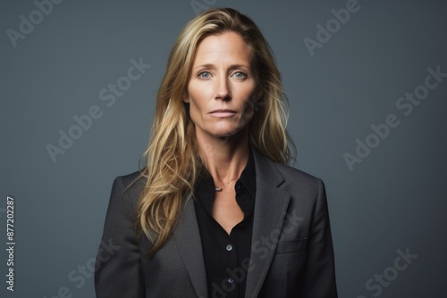 Portrait of a serious businesswoman looking at camera against grey background