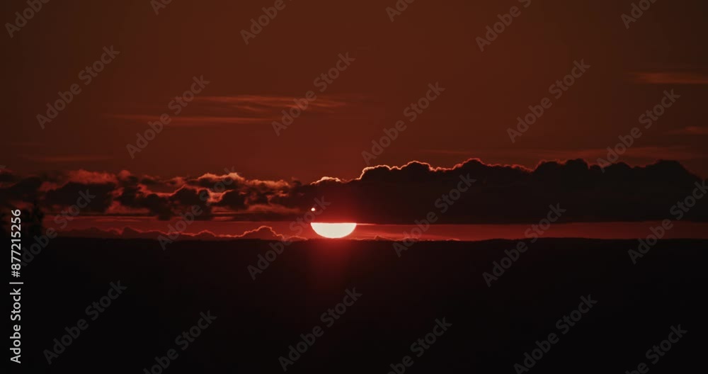 Sunset Sky Over Hills with Clouds and Light Timelapse: The setting sun colors the clouds in red and golden tones, slowly drifting over the hills, creating a magnificent view.