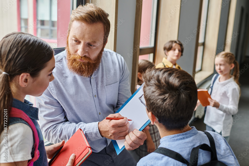 © LIGHTFIELD STUDIOS - A bearded man teacher engages a group of children in a lively classroom, imparting knowledge and wisdom through storytelling. © LIGHTFIELD STUDIOS - A bearded man teacher engages a group of children in a lively classroom, imparting knowledge and wisdom through storytelling.