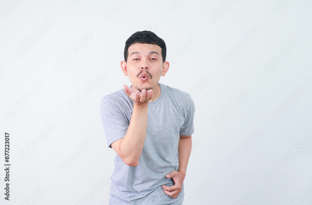 a young Asian man is making a kiss gesture a young Asian man is making a kiss gesture