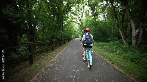 Wallpaper Mural Rear view of cycling couple on tandem bike on a paved rail trail in a forest. Torontodigital.ca