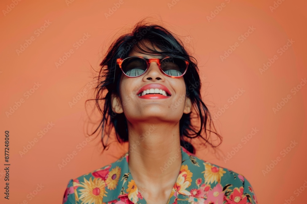 Portrait of a joyful indian woman in her 30s wearing a trendy sunglasses over solid color backdrop Portrait of a joyful indian woman in her 30s wearing a trendy sunglasses over solid color backdrop