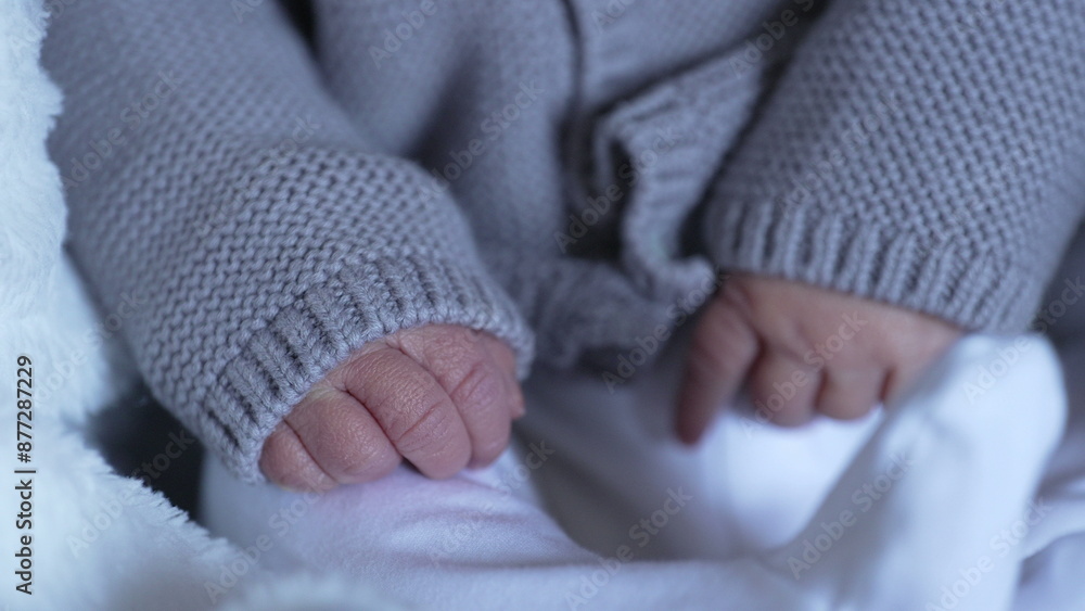Tiny hands of a newborn baby peeking out from a knitted sweater, capturing the delicate and fragile nature of newborns and early life Tiny hands of a newborn baby peeking out from a knitted sweater, capturing the delicate and fragile nature of newborns and early life