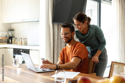 Adult couple using laptop computer at home.