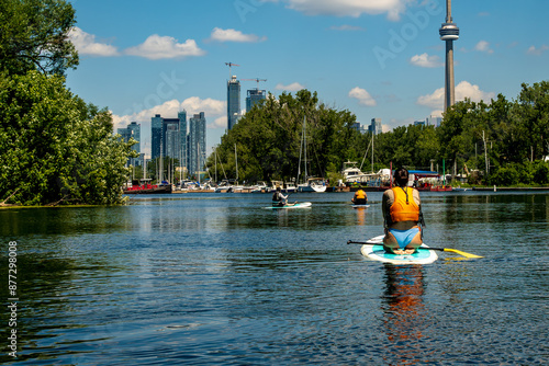Photography paddling on a channel  in the toronto islands in summer with the city skyline an