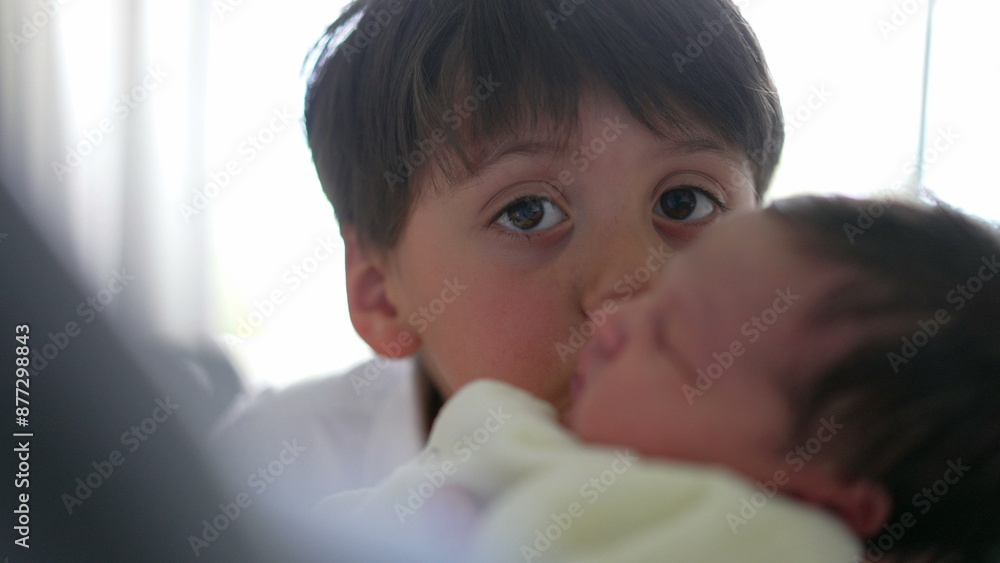 Young boy gently kissing his newborn sibling, expressing pure affection and love. The closeness and focus on their faces highlight the strong bond and tender relationship between them Young boy gently kissing his newborn sibling, expressing pure affection and love. The closeness and focus on their faces highlight the strong bond and tender relationship between them