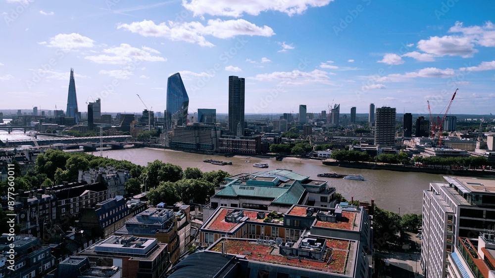 Obraz premium Drone image of the London Skyline featuring clear blue sky with a few clouds