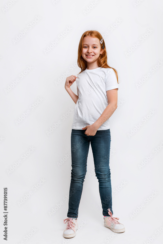 Kid in white t-shirt and jeans posing in studio. Full length portrait little girl Kid in white t-shirt and jeans posing in studio. Full length portrait little girl