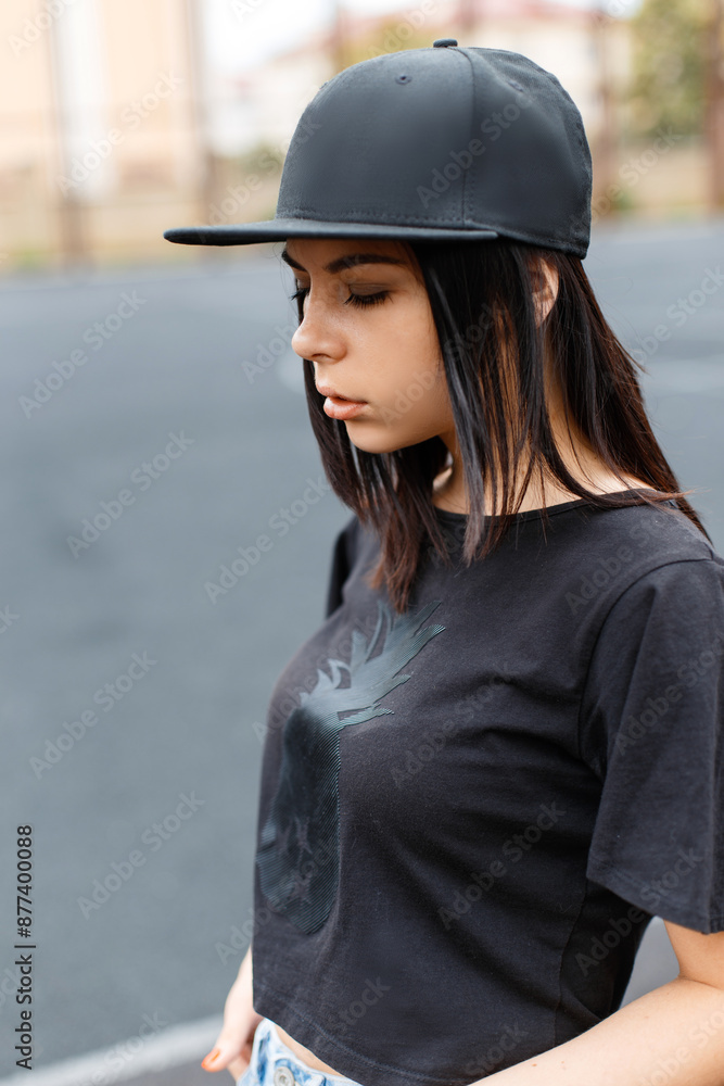 Beautiful young stylish woman hipster model with a black baseball cap with t-shirt at the stadium Beautiful young stylish woman hipster model with a black baseball cap with t-shirt at the stadium