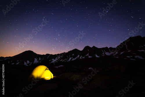 Photo d'une tente la nuit lors d'un bivouac en montagne