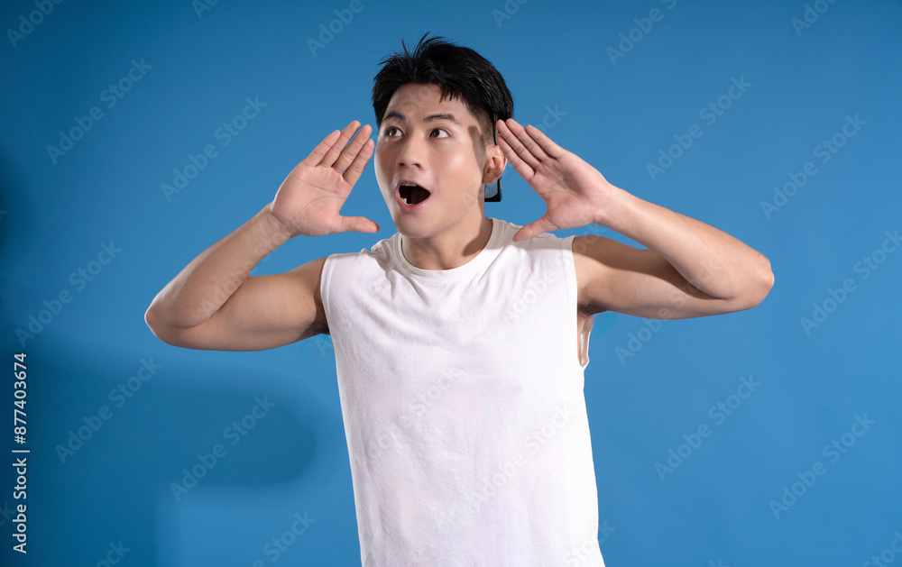 Portrait of asian guy wearing summer outfit and posing on blue background Portrait of asian guy wearing summer outfit and posing on blue background