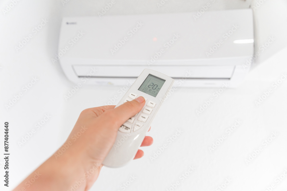 Hand Holding Remote Control Adjusting Air Conditioner Hand Holding Remote Control Adjusting Air Conditioner