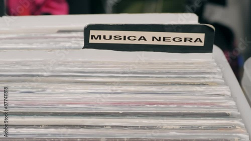 People browsing vinyl records in a music store, surrounded by retro albums in physical format photo