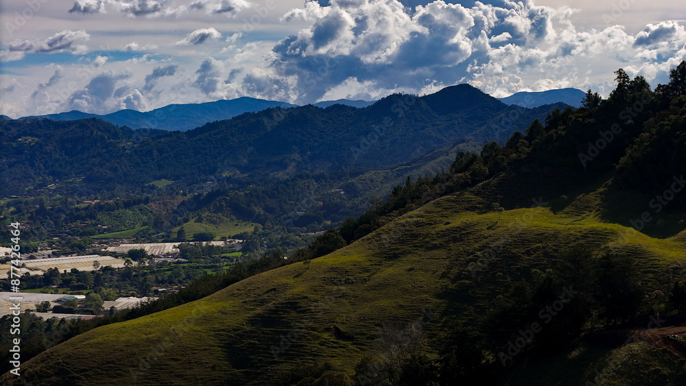 Naklejka premium Foto aérea en zona rural del municipio de La Ceja, Antioquia, Colombia. Se disfruta del hermoso contraste entre el verde de sus montañas y el cielo azul