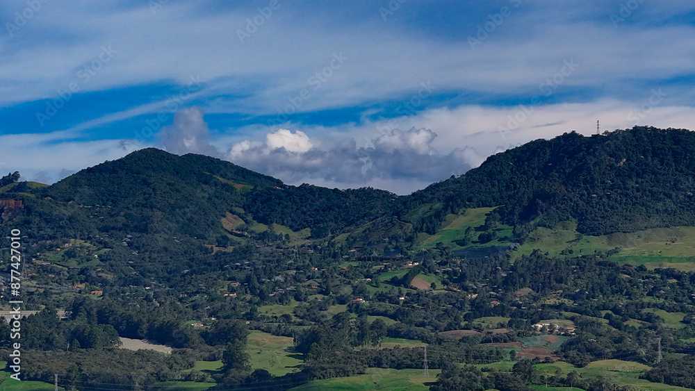 Obraz premium Foto aérea en zona rural del municipio de La Ceja, Antioquia, Colombia. Se disfruta del hermoso contraste entre el verde de sus montañas y el cielo azul