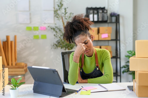 Obraz na plátně Young business owner is struggling with a headache while juggling her online bus