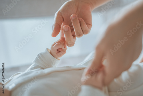 Foto Close-up little hand of child baby holding hand of mother, A newborn holds on to