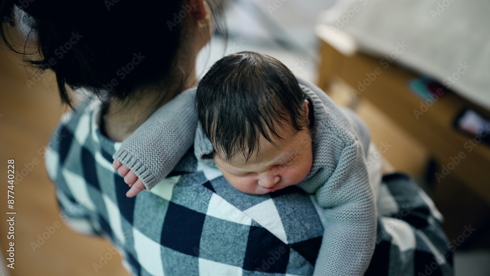 Mother gently cradling her newborn baby on her shoulder in a serene, sunlit room. The baby is peacefully sleeping, highlighting the love and tenderness in their bond Mother gently cradling her newborn baby on her shoulder in a serene, sunlit room. The baby is peacefully sleeping, highlighting the love and tenderness in their bond