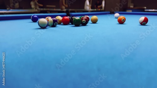 Middle shot. Woman breaking racked pool balls in eight-ball on billiard table