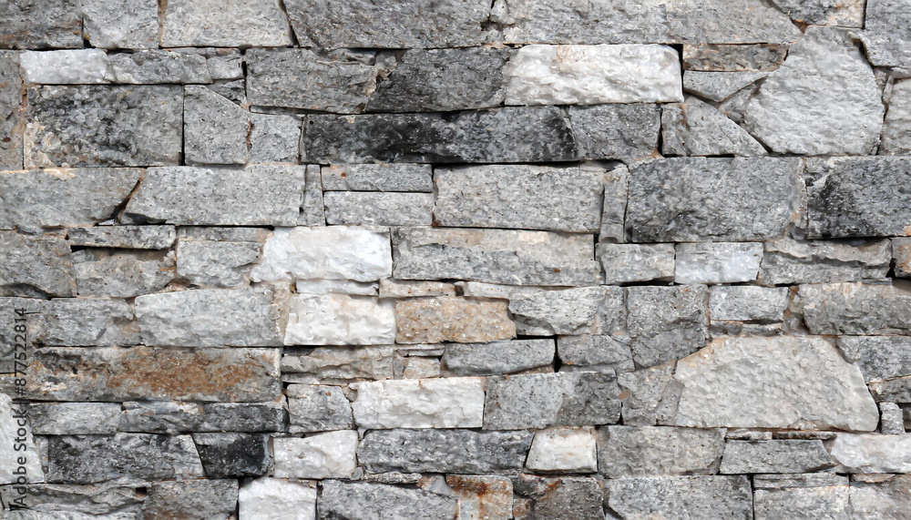 Stone wall texture background - grey stone siding with different sized stones Stone wall texture background - grey stone siding with different sized stones
