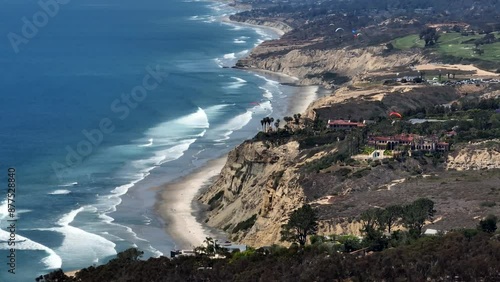 Aerial view of paragliders flying over La Jolla with views of luxury homes along the cliffs and the Pacific Ocean by Scripps Research institute in San Diego on a sunny day photo