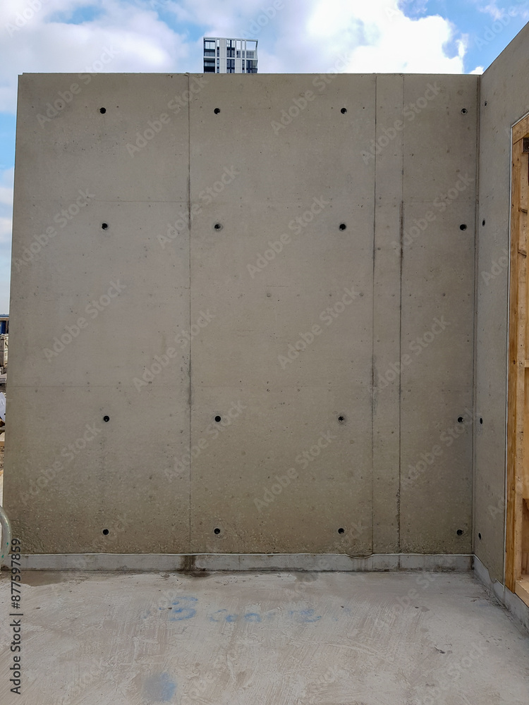 Architectural visual concrete finish mockup at construction site. Standalone concrete structure with visible formwork and smooth finish. Industrial construction and building design. Architectural visual concrete finish mockup at construction site. Standalone concrete structure with visible formwork and smooth finish. Industrial construction and building design.