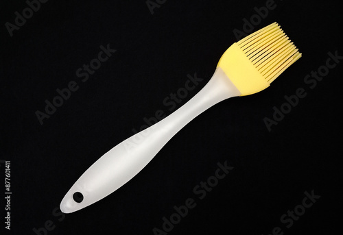 Photos A basting brush with silicone bristles on black fabric.