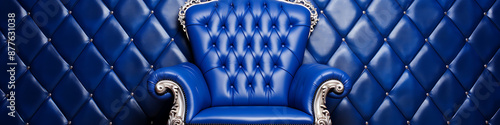 A luxurious blue armchair with silver accents against a blue tufted background evokes elegance and sophistication for interior design projects.  photo