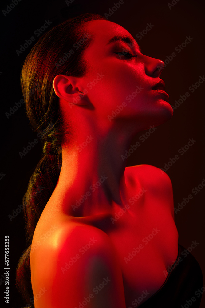 Vertical photo of dreamy feminine lady nude shoulders seduce you isolated black orange neon light background Vertical photo of dreamy feminine lady nude shoulders seduce you isolated black orange neon light background