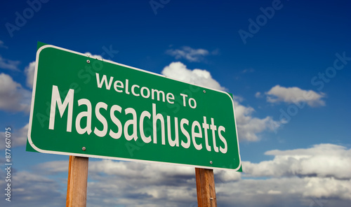 Welcome To Massachusetts Green Road Sign Over Blue Sky with Some Clouds.