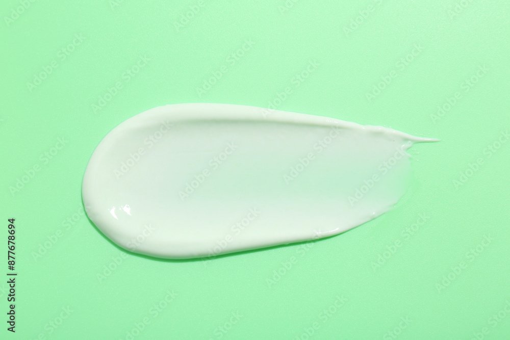 Sample of face cream on green background, top view Sample of face cream on green background, top view