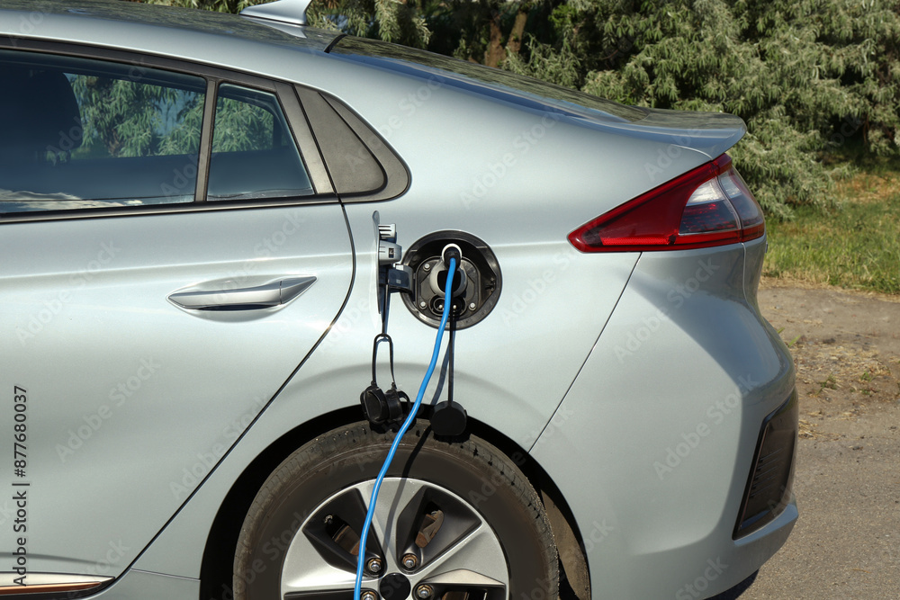 Charging modern electric car from station outdoors Charging modern electric car from station outdoors