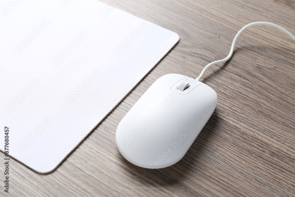 Computer mouse with mousepad on wooden desk, closeup Computer mouse with mousepad on wooden desk, closeup