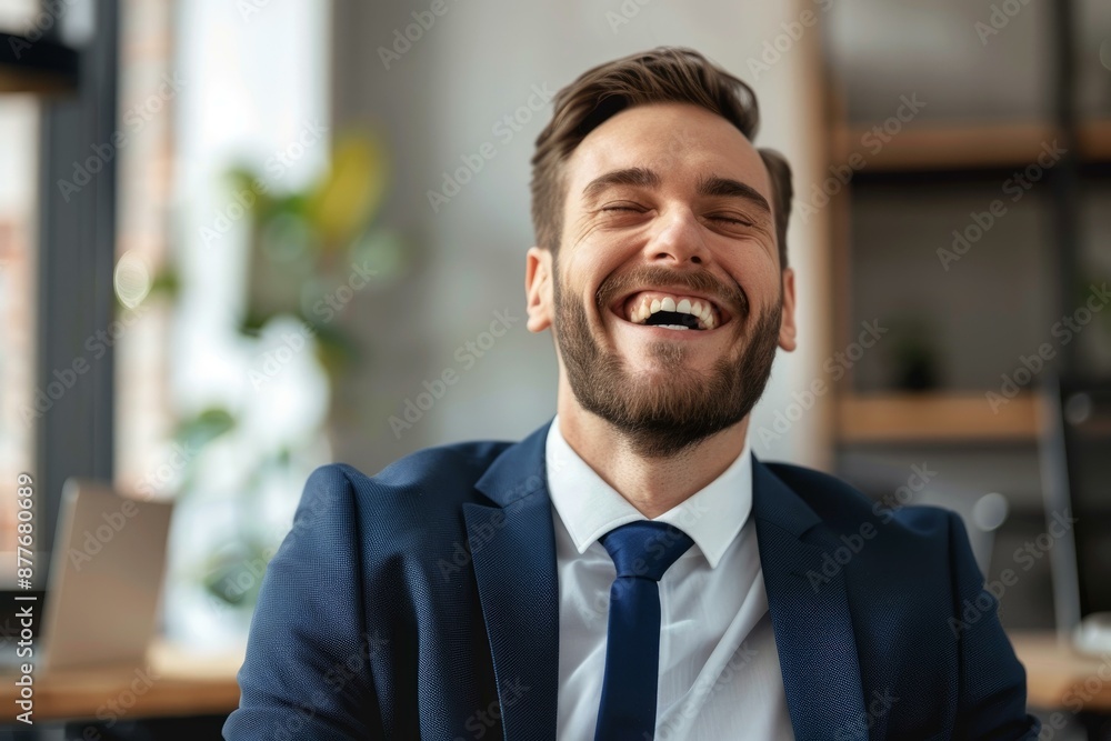 Businessman with a beard wearing a suit and tie laughing in an office setting Businessman with a beard wearing a suit and tie laughing in an office setting