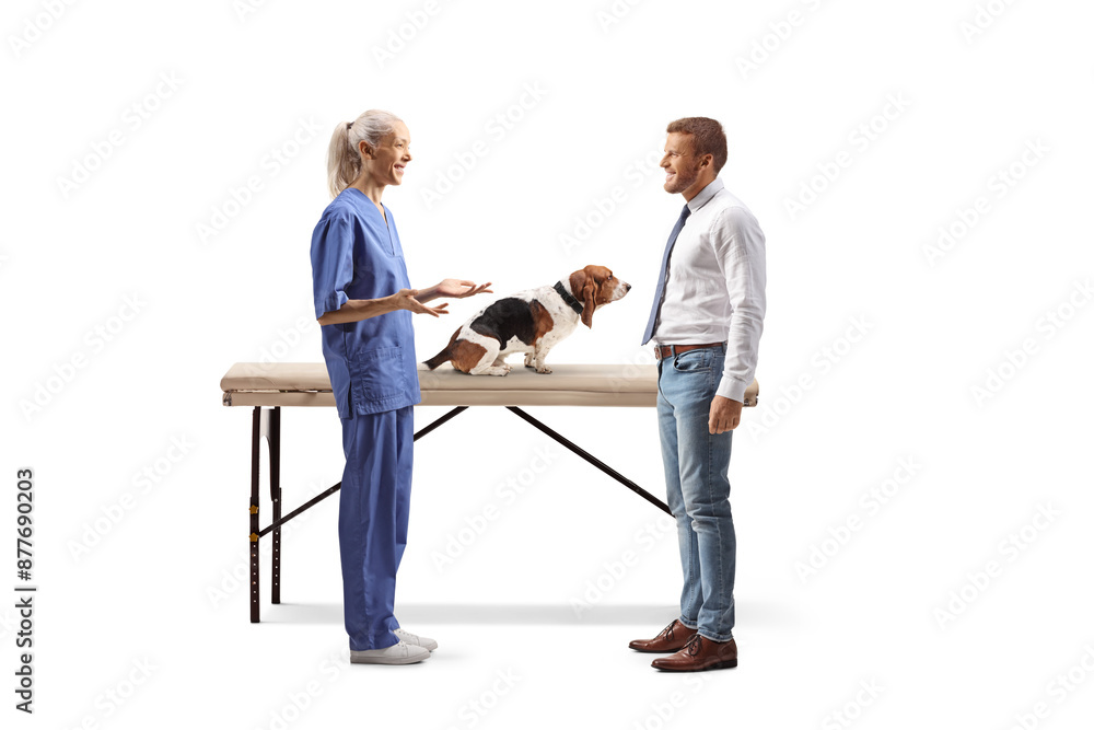 Female veterinarian talking to a man with a basset hound dog Female veterinarian talking to a man with a basset hound dog