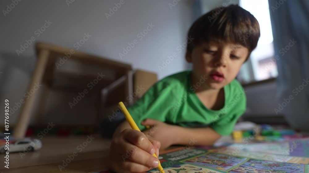 Boy In Green Shirt Drawing With Yellow Marker On Floor, Cozy Home Environment, Focused On Coloring Book, Engaged In Creative Activity, Natural Light, Indoors, Childhood Fun Boy In Green Shirt Drawing With Yellow Marker On Floor, Cozy Home Environment, Focused On Coloring Book, Engaged In Creative Activity, Natural Light, Indoors, Childhood Fun