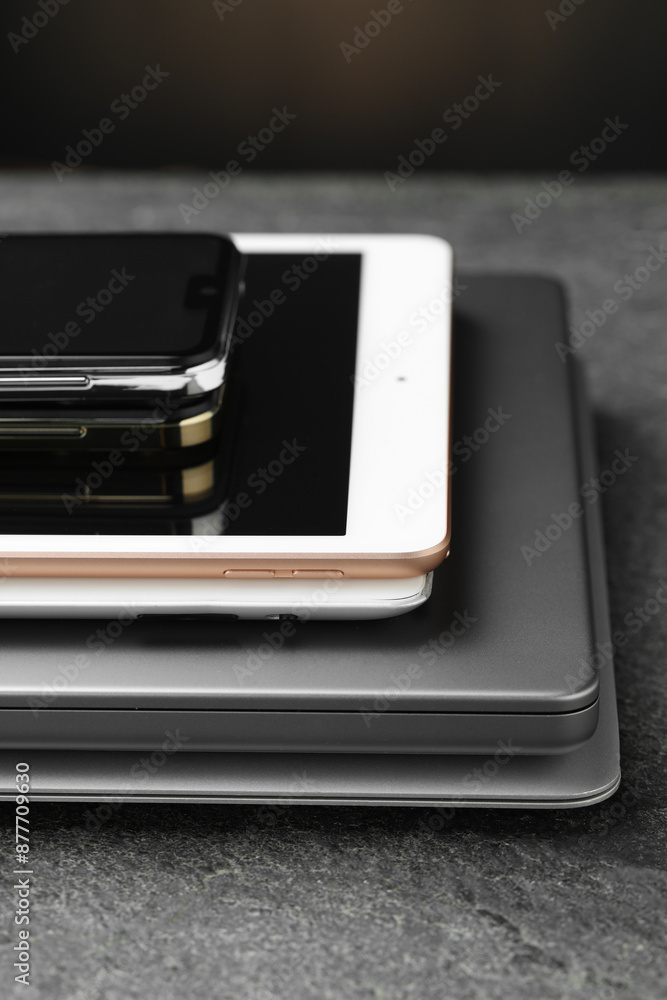 Stack of electronic devices on grey table, closeup Stack of electronic devices on grey table, closeup
