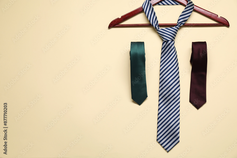 Obraz premium Hanger and neckties on beige background, flat lay. Space for text