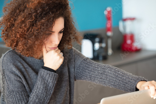 Curly-haired woman, deep thought, analyzing online information